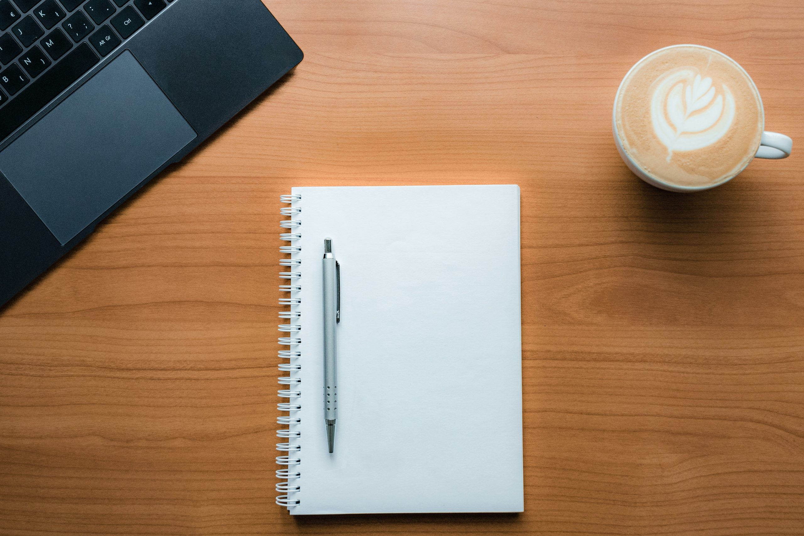 notebook and pen on desk as part of digital detox for remote workers