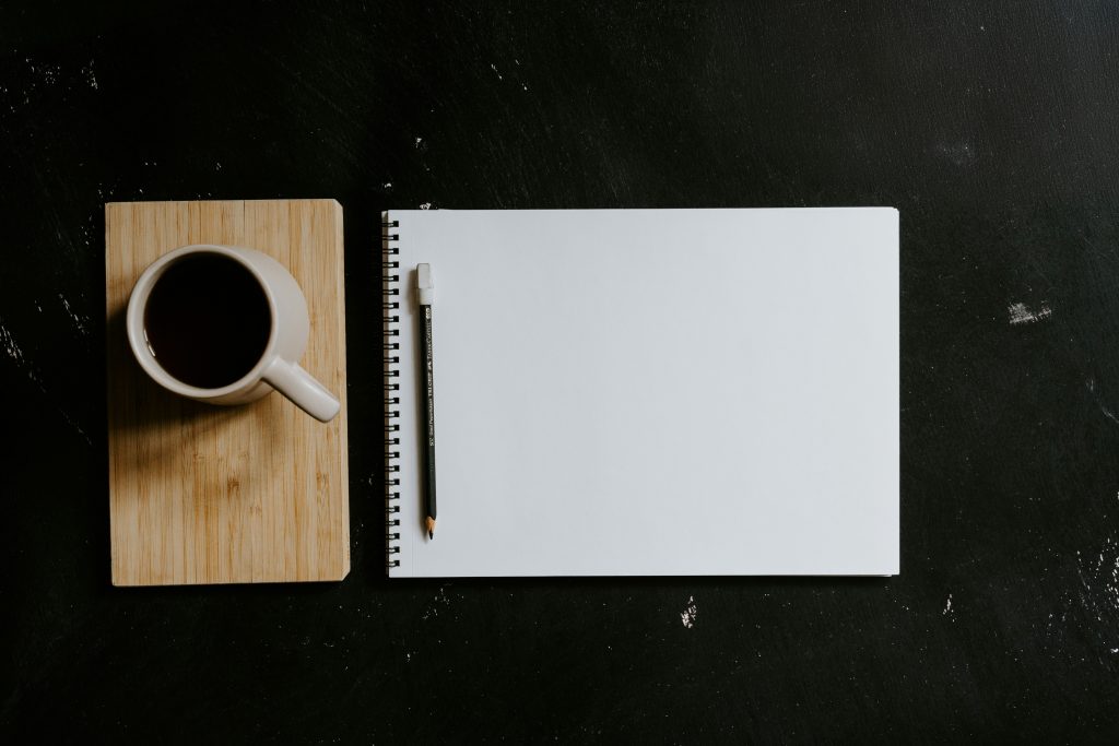 eat the frog method notebook and coffee on desk