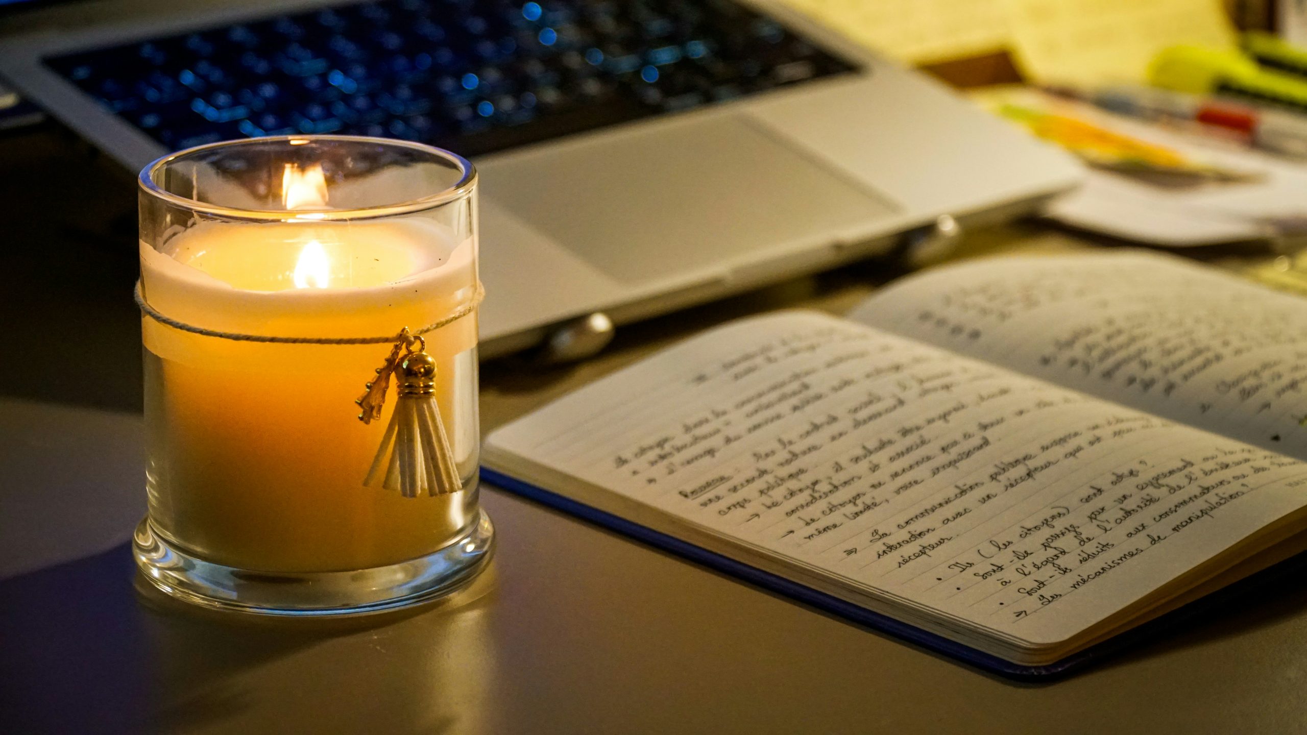 evening routine setup — notebook and candle on desk for end-of-day planning