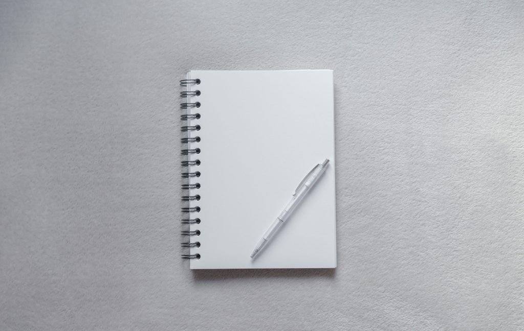 ivy lee method for productivity white notebook with pen on plain surface