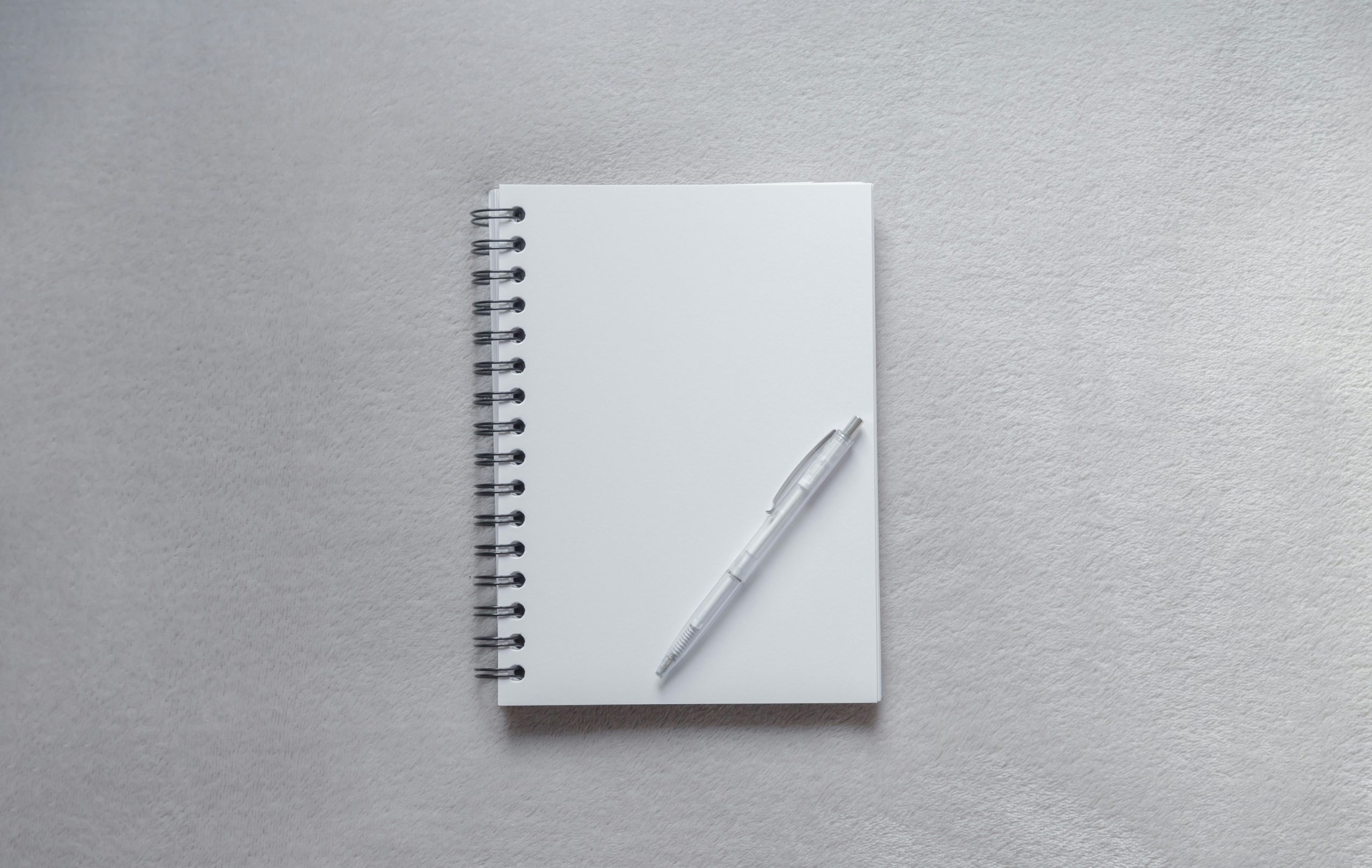 ivy lee method for productivity white notebook with pen on plain surface