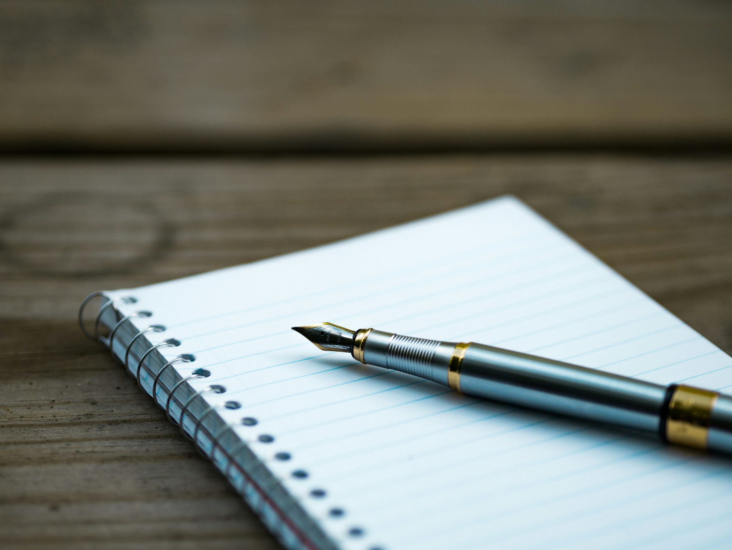 fountain pen on spiral notebook for comparing note-taking apps
