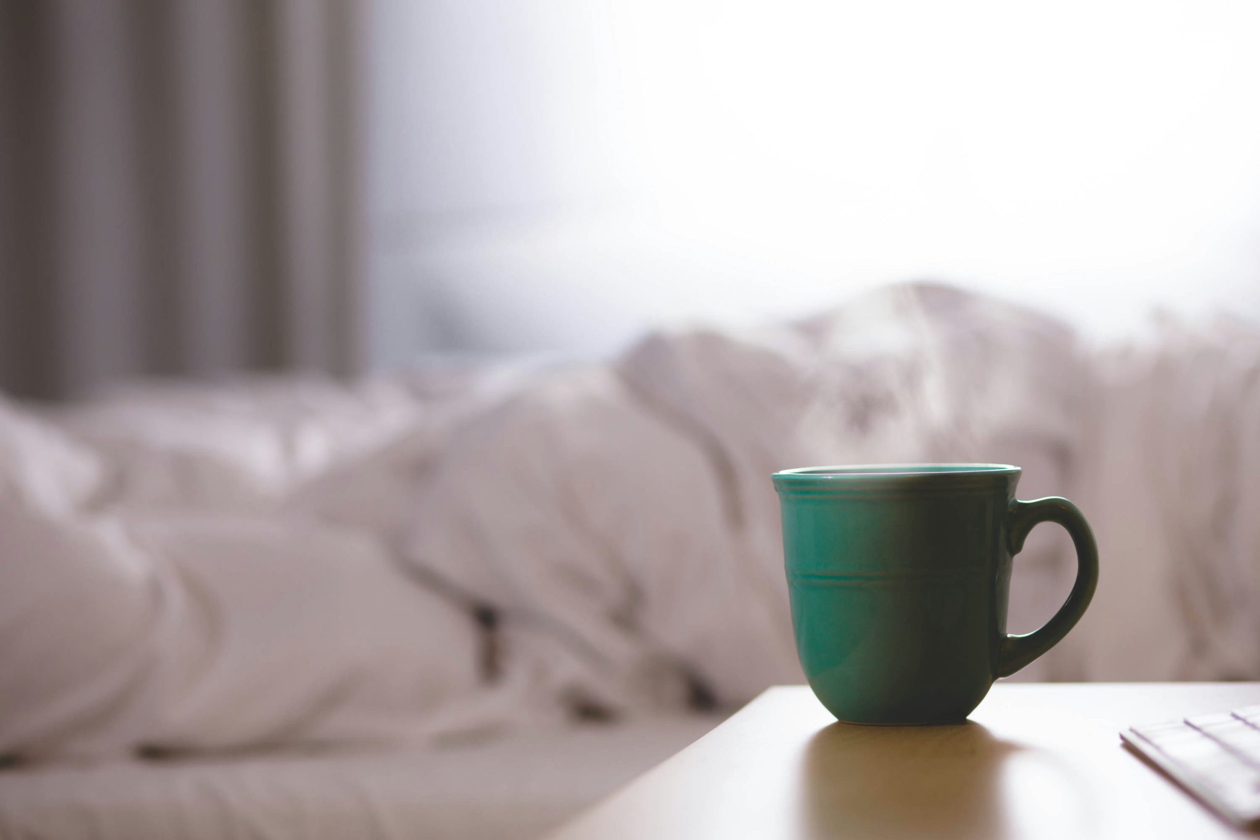 green mug on desk for daily habit practice with seinfeld strategy