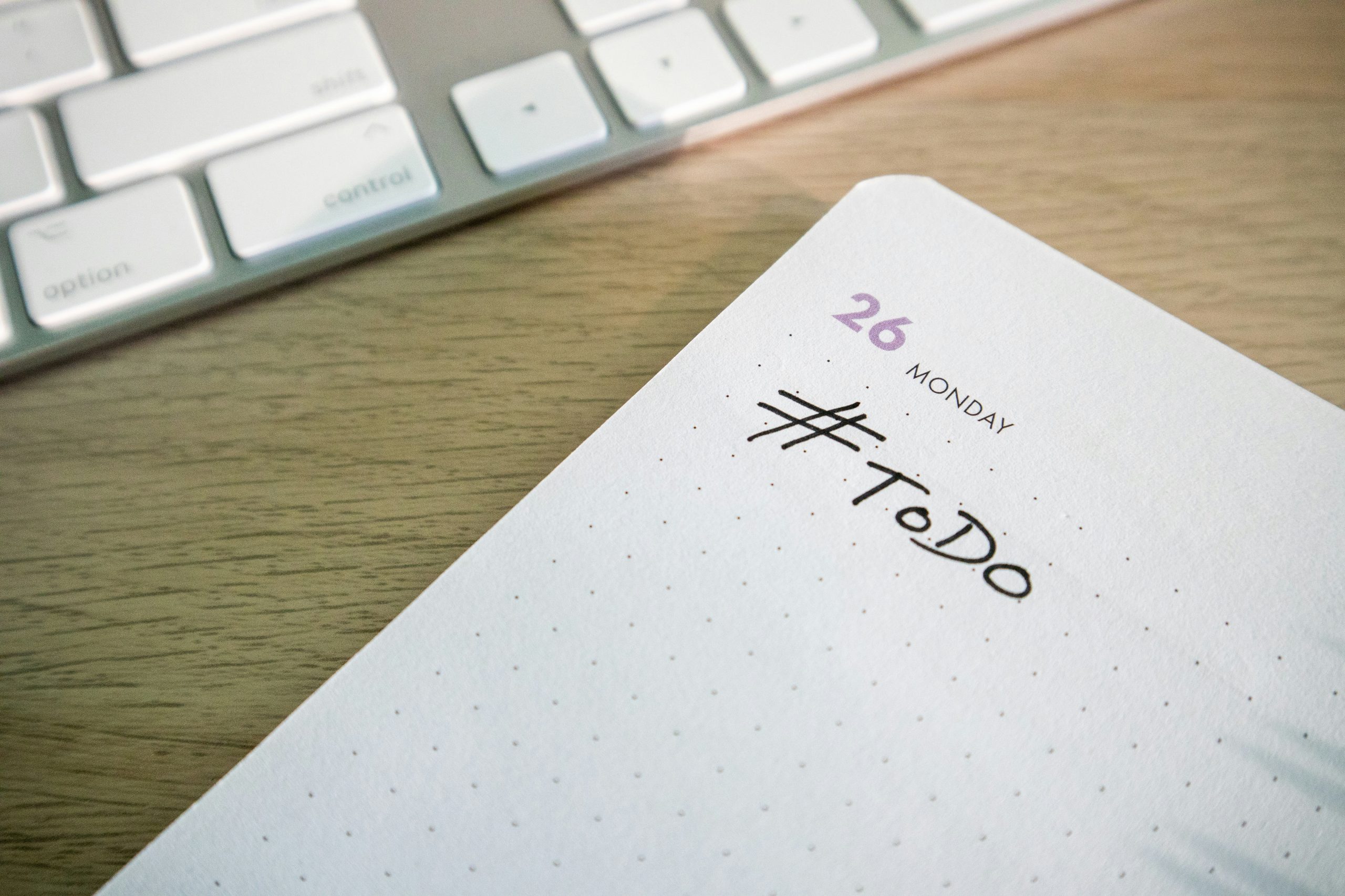 notepad with task list next to keyboard for task management apps