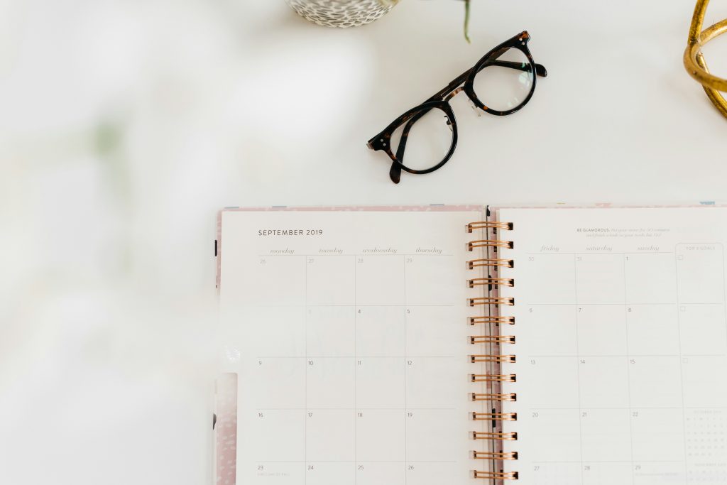 weekly review productivity planner and glasses on desk
