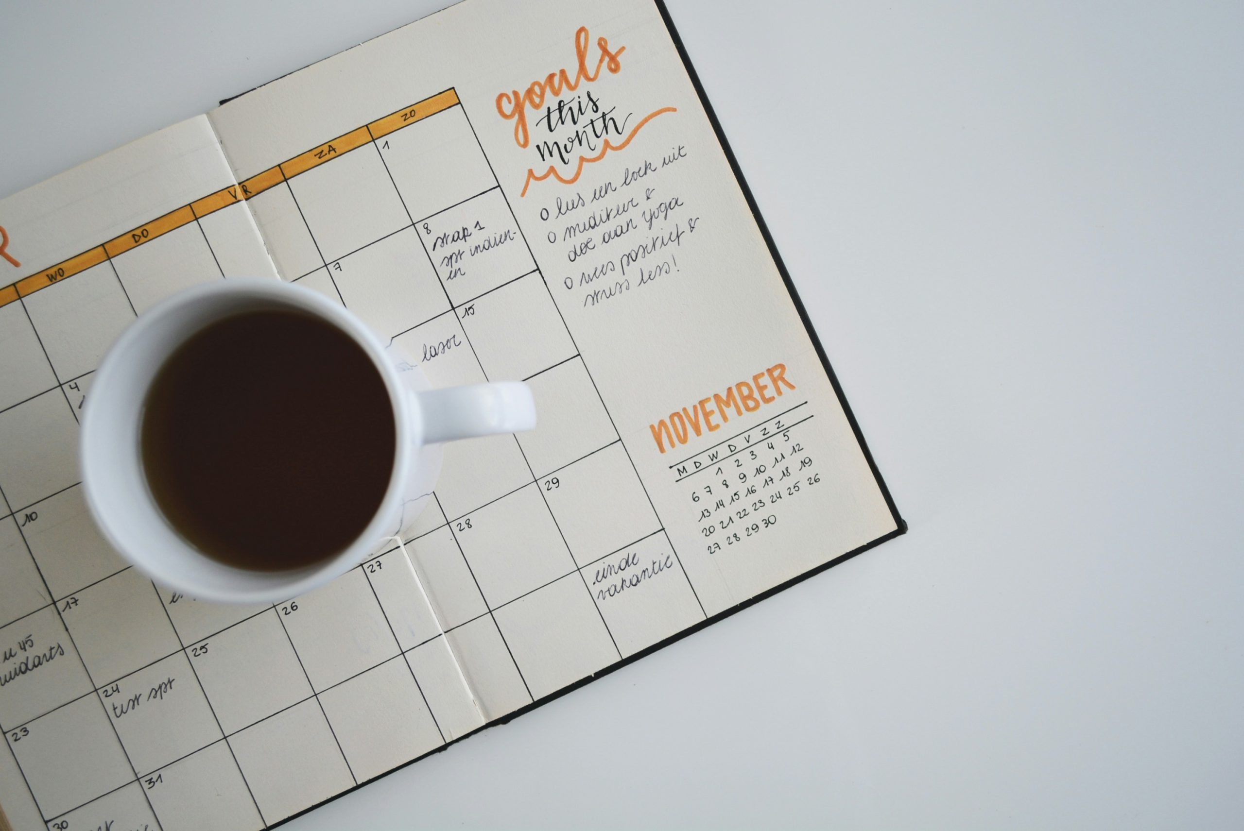 coffee mug on planner for async work schedule