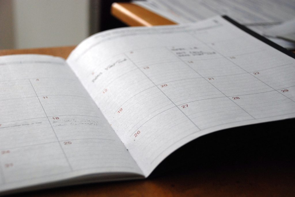 open monthly planner on desk for async work planning