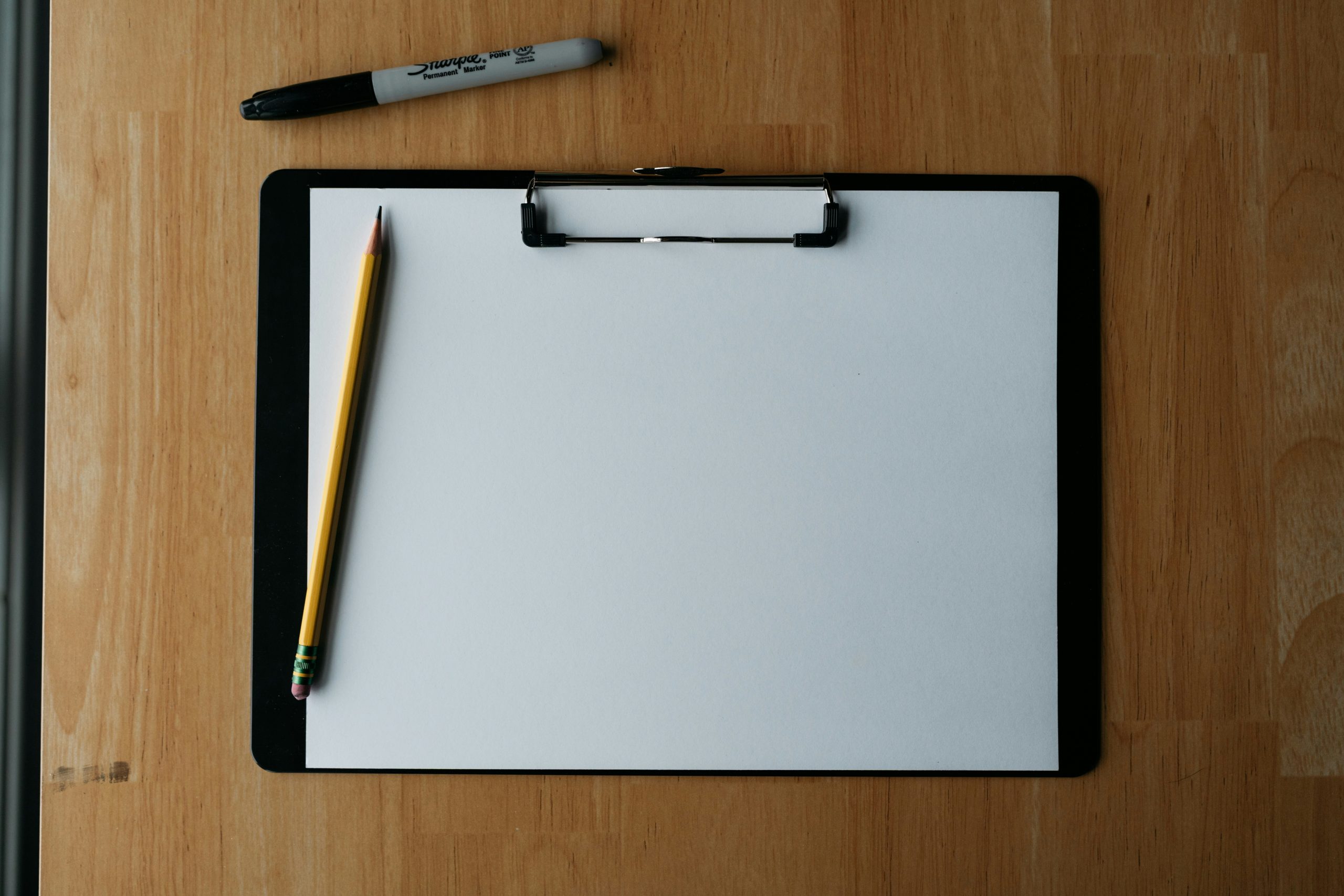 clipboard and pen used for a weekly productivity status report